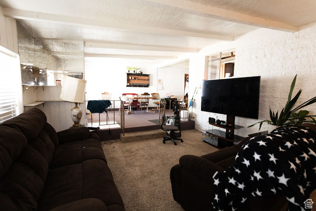 Living room with carpet flooring and beam ceiling