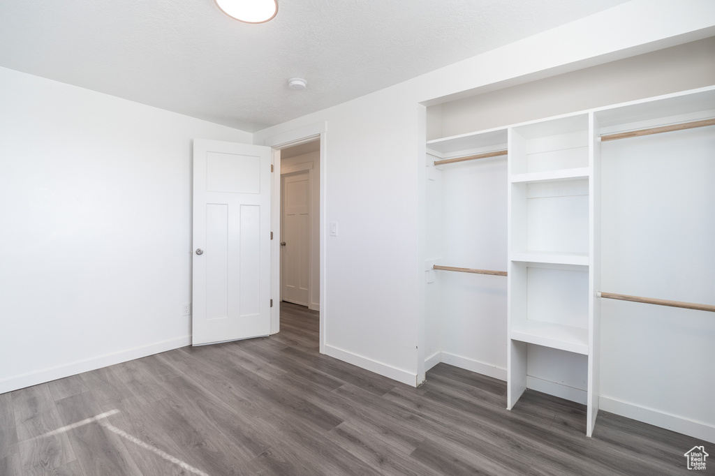 Unfurnished bedroom featuring wood finished floors and a closet