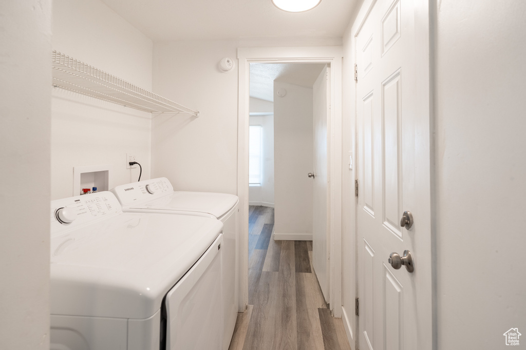 Laundry area featuring washer and clothes dryer and light wood-type flooring