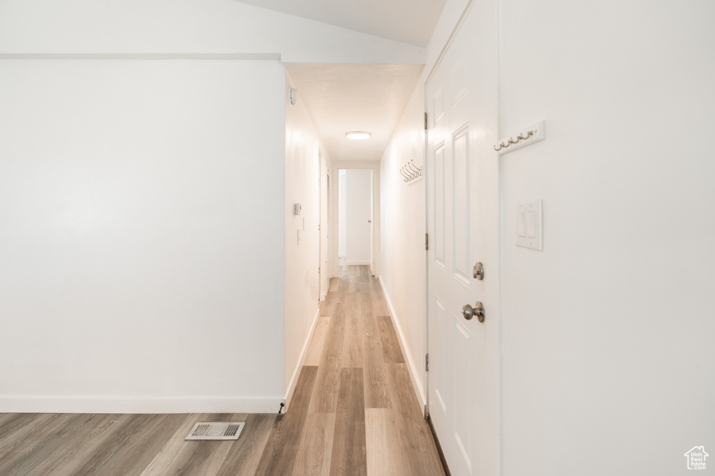 Corridor with light wood finished floors and baseboards