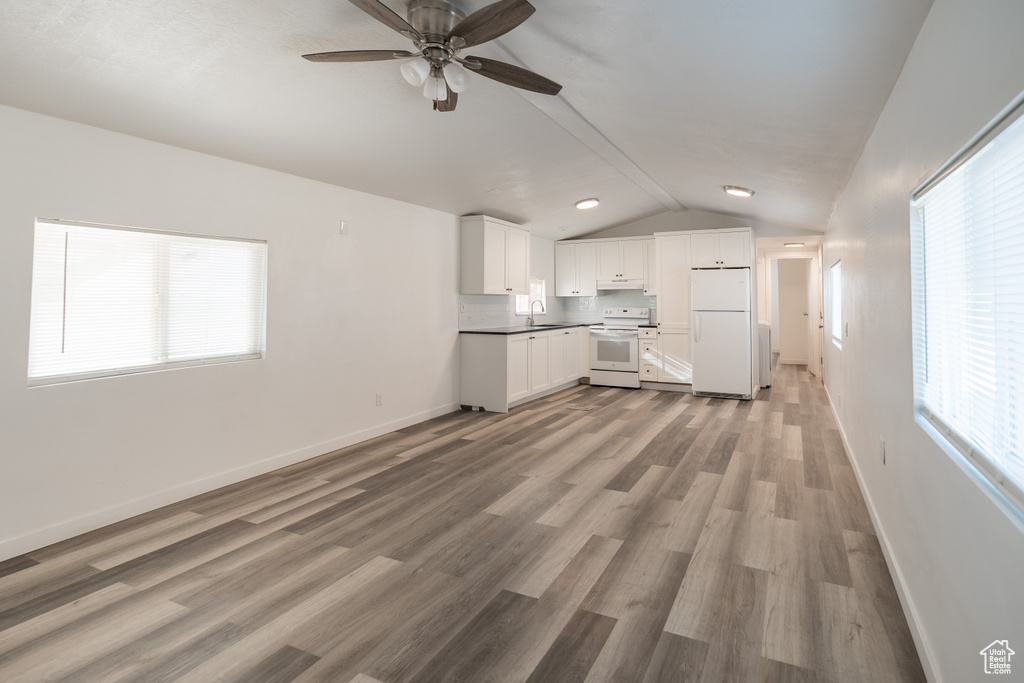 Unfurnished living room with lofted ceiling, ceiling fan, and wood finished floors