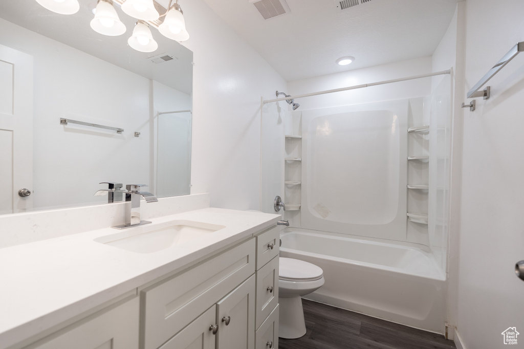 Bathroom with vanity, wood finished floors, and  shower combination