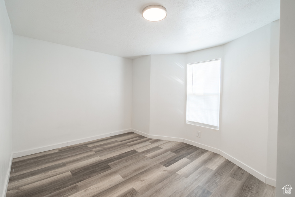 Unfurnished room with light wood-style flooring and baseboards