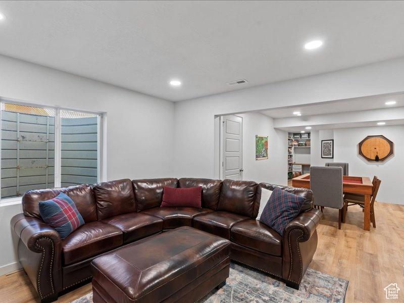 Living area with light wood-style flooring and recessed lighting