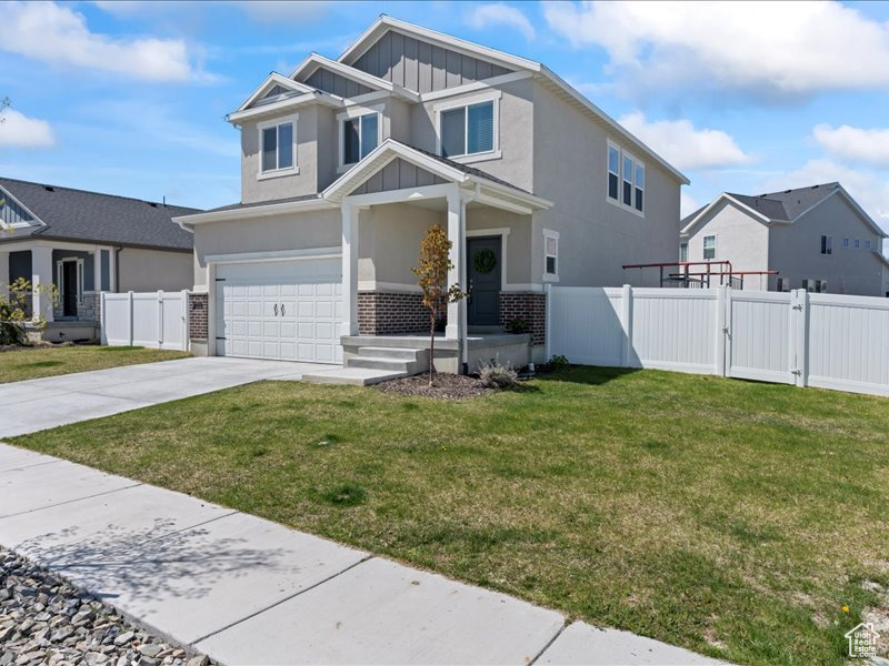 Craftsman inspired home with board and batten siding, a garage, concrete driveway, a gate, and stucco siding