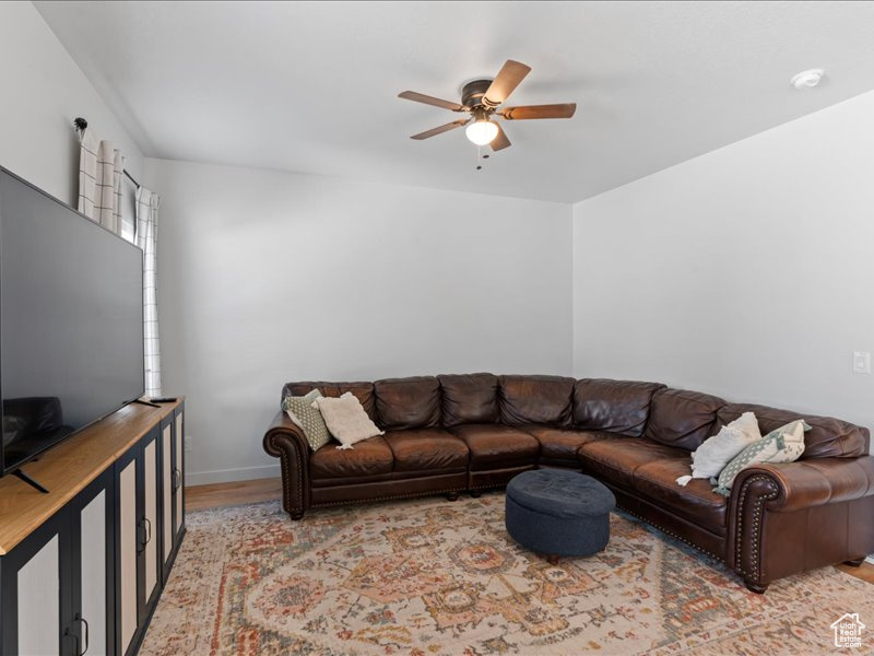 Living room featuring a ceiling fan and wood finished floors