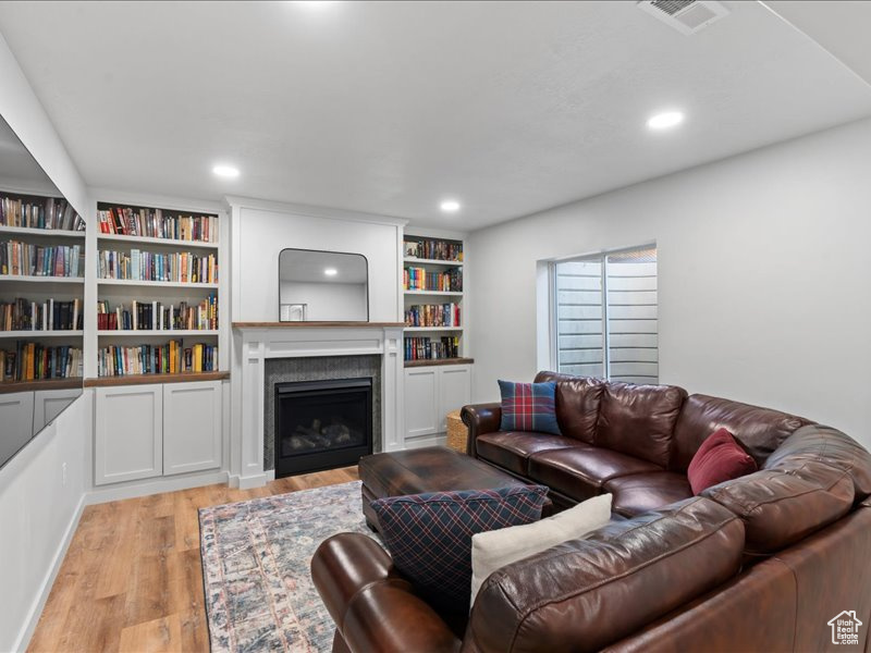 Living area featuring light wood-style floors, a fireplace, and recessed lighting