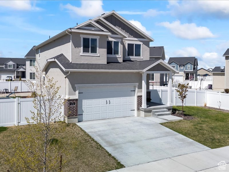 Craftsman-style home with stucco siding, a garage, concrete driveway, and a residential view