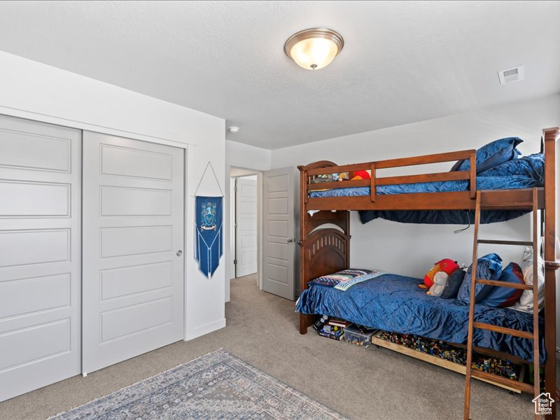 Bedroom featuring carpet flooring and a closet