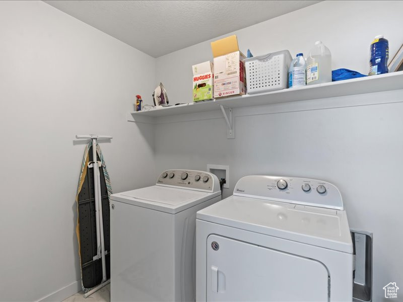 Washroom with washing machine and clothes dryer and baseboards