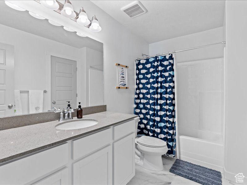 Full bath with vanity, shower / bathtub combination with curtain, and marble look tiles