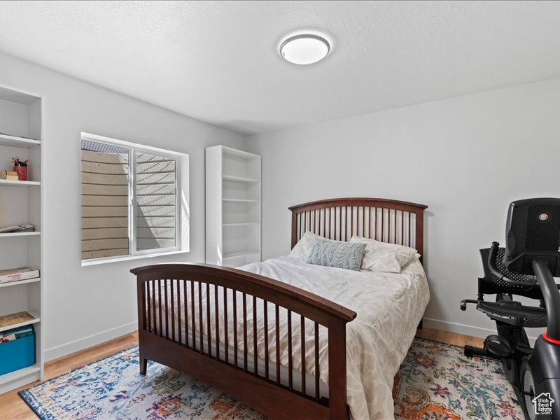 Bedroom featuring wood finished floors and baseboards