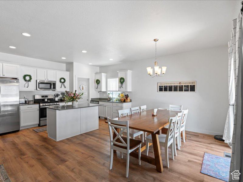 Dining space featuring a chandelier, wood finished floors, and recessed lighting