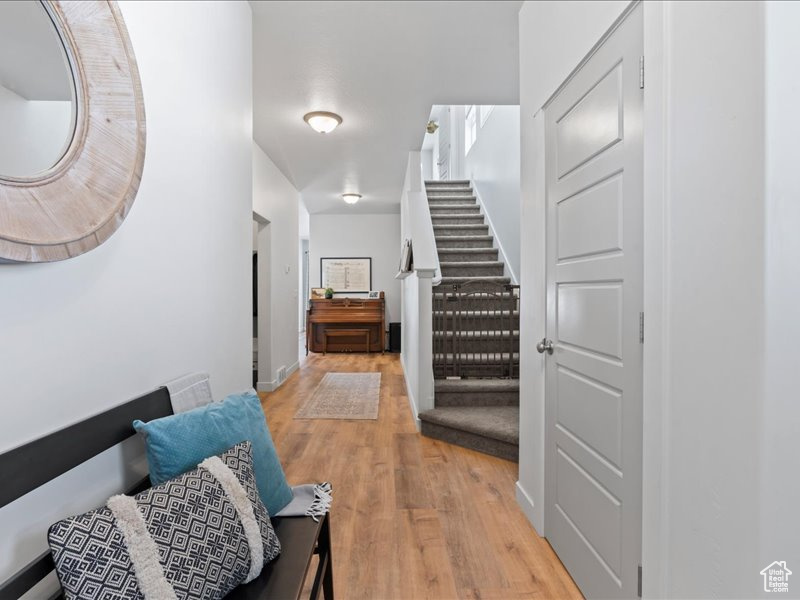 Hall with light wood finished floors and stairs