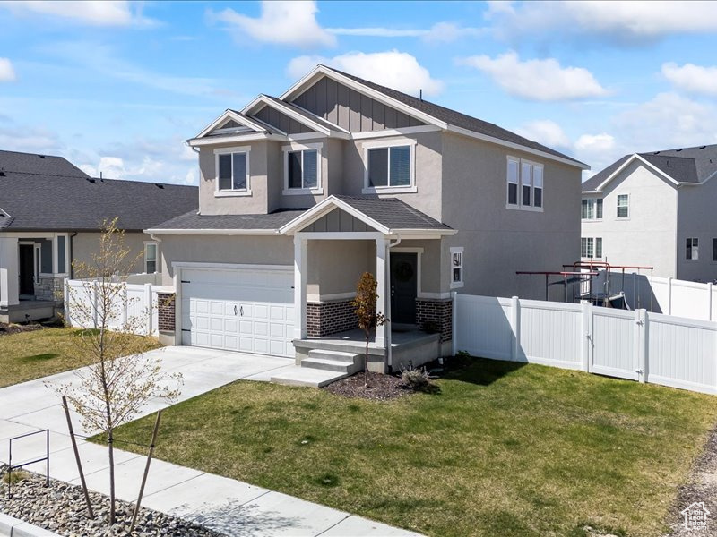 View of front of property featuring board and batten siding, an attached garage, concrete driveway, and stucco siding
