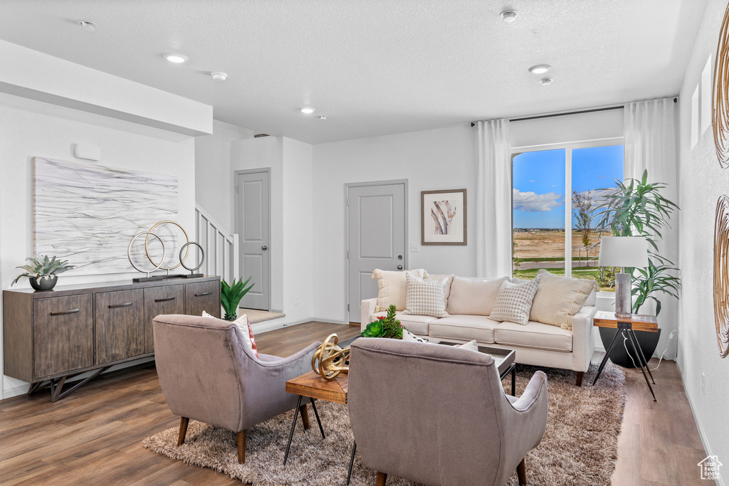 Living room with dark wood-style floors, recessed lighting, and a textured ceiling