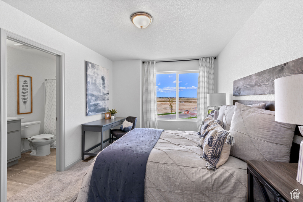 Bedroom featuring a textured ceiling and connected bathroom