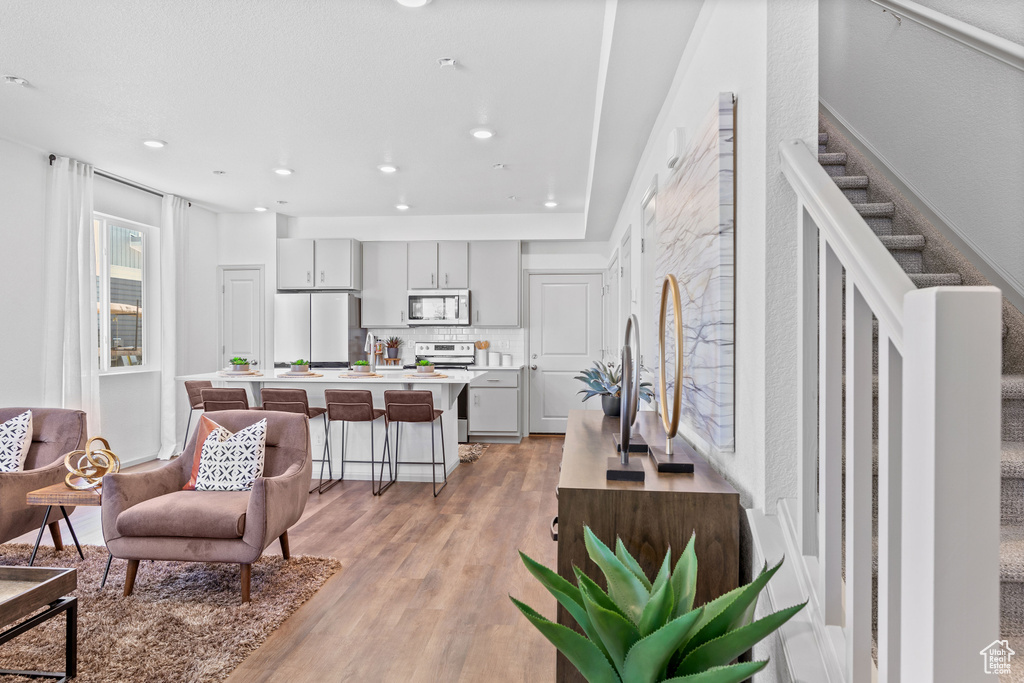 Living room with light wood-style flooring and recessed lighting