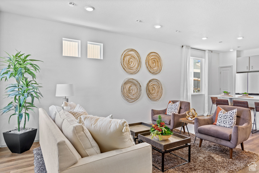 Living room with light wood-type flooring and recessed lighting
