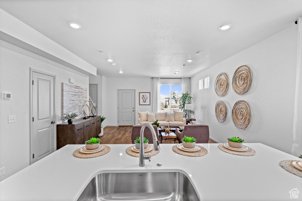 Kitchen featuring light countertops, recessed lighting, wood finished floors, and open floor plan