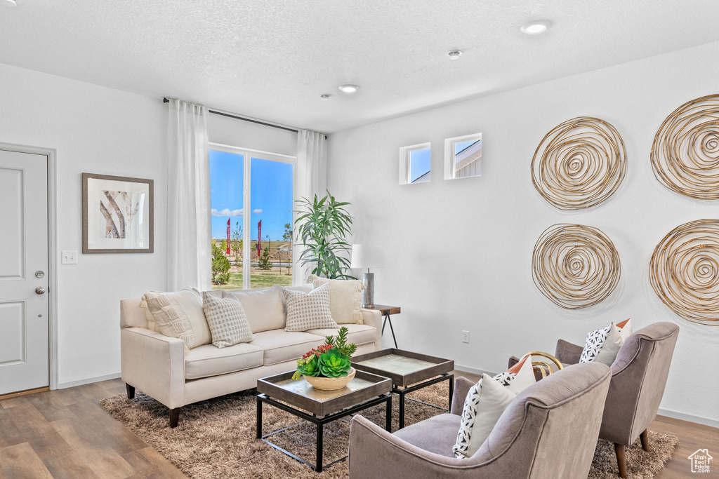 Living area with wood finished floors and recessed lighting