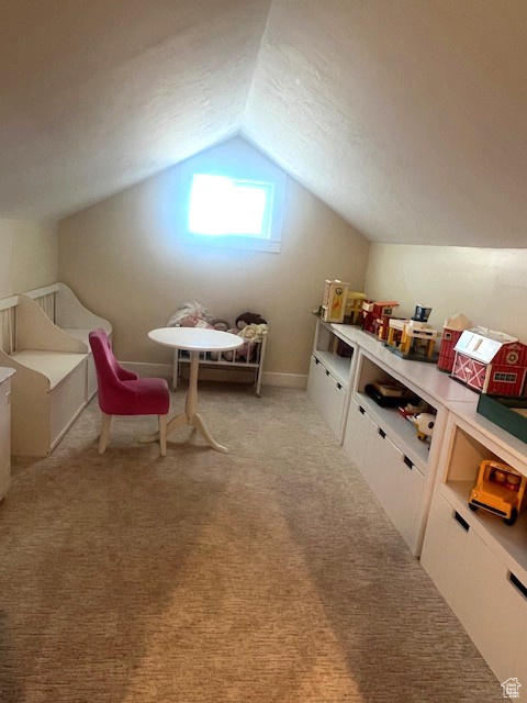 Additional living space featuring vaulted ceiling and light colored carpet