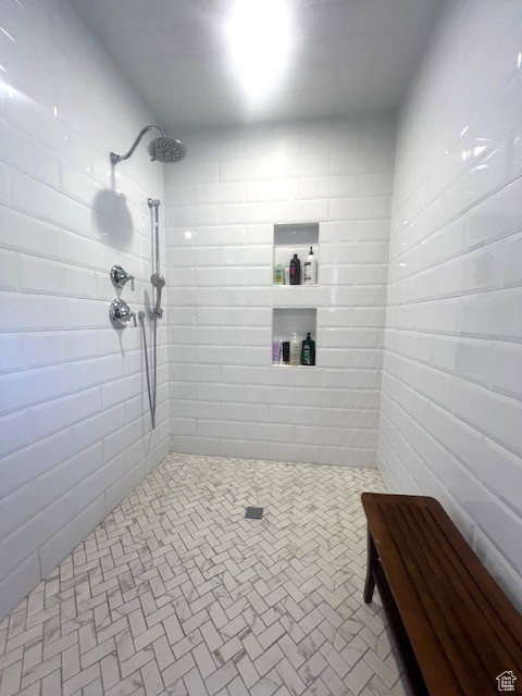 Bathroom with tiled shower and brick patterned floors