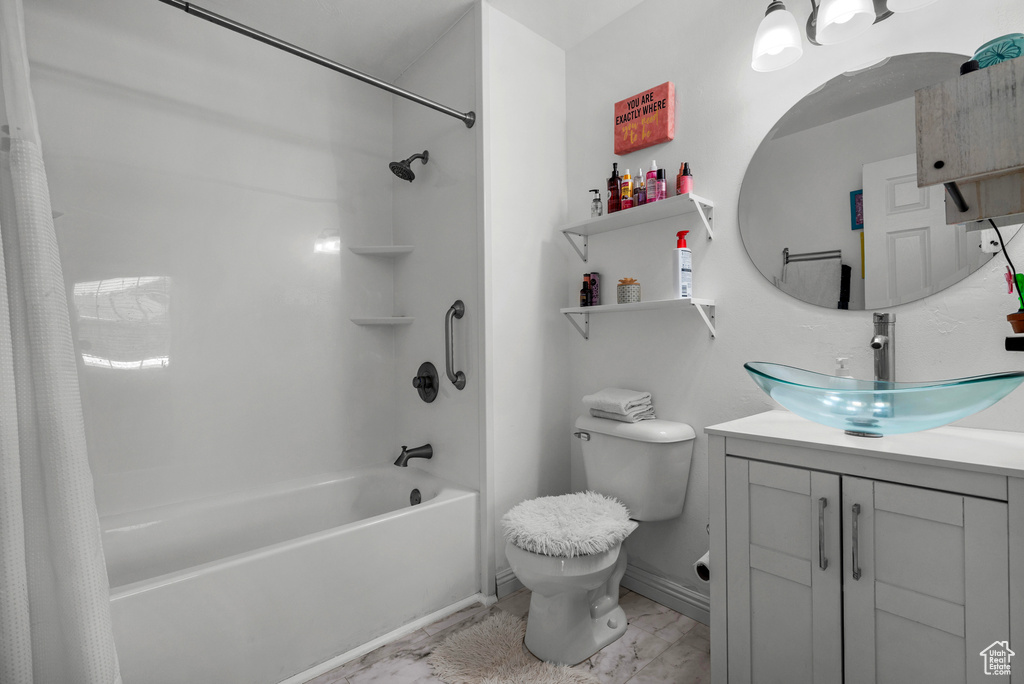 Full bathroom with shower / bath combination with curtain, marble look tiles, and vanity