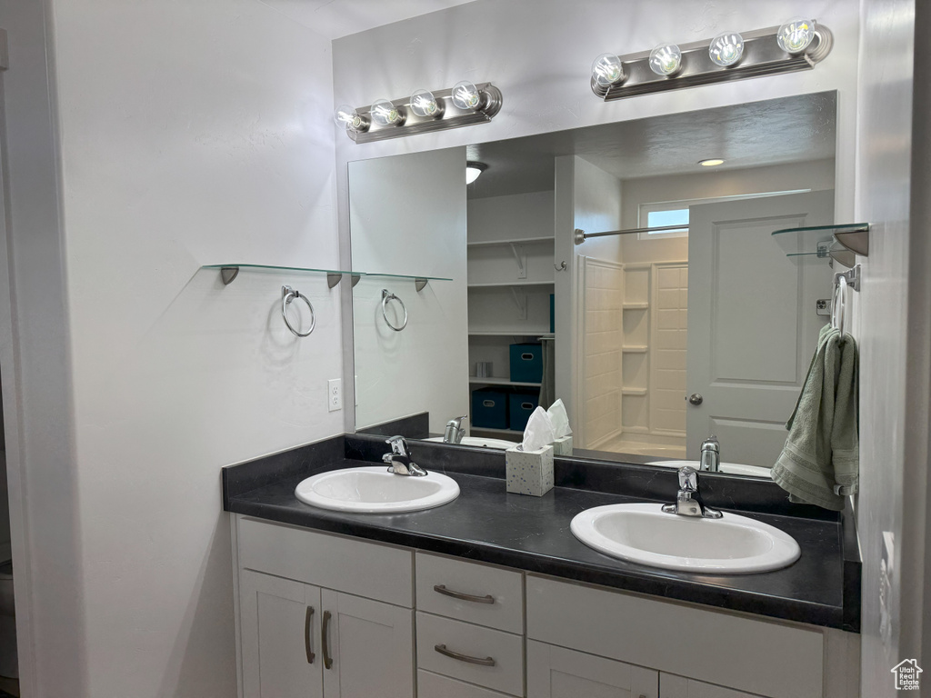 Bathroom featuring double vanity and a shower