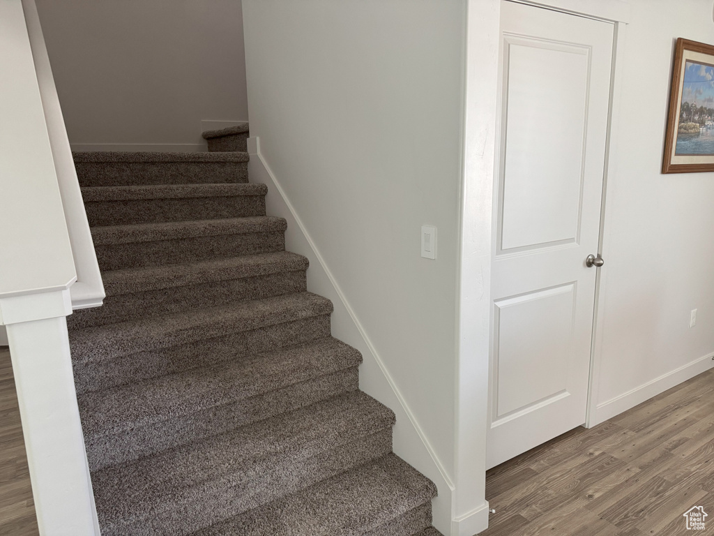 Stairs featuring wood finished floors and baseboards