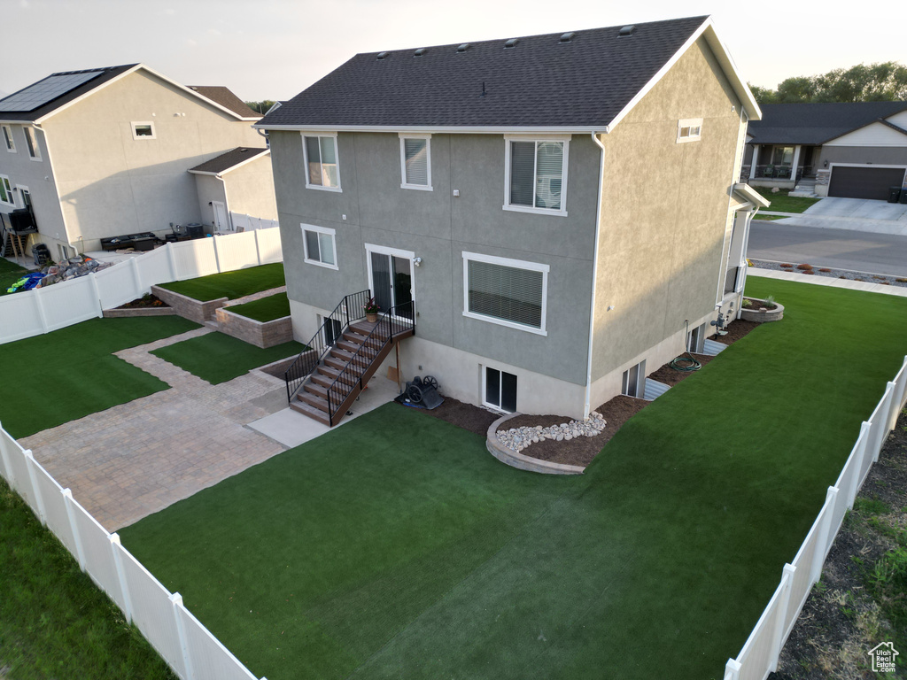 Back of house featuring stucco siding, a fenced backyard, and a patio area
