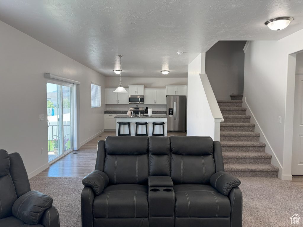 Living area featuring stairway and light colored carpet