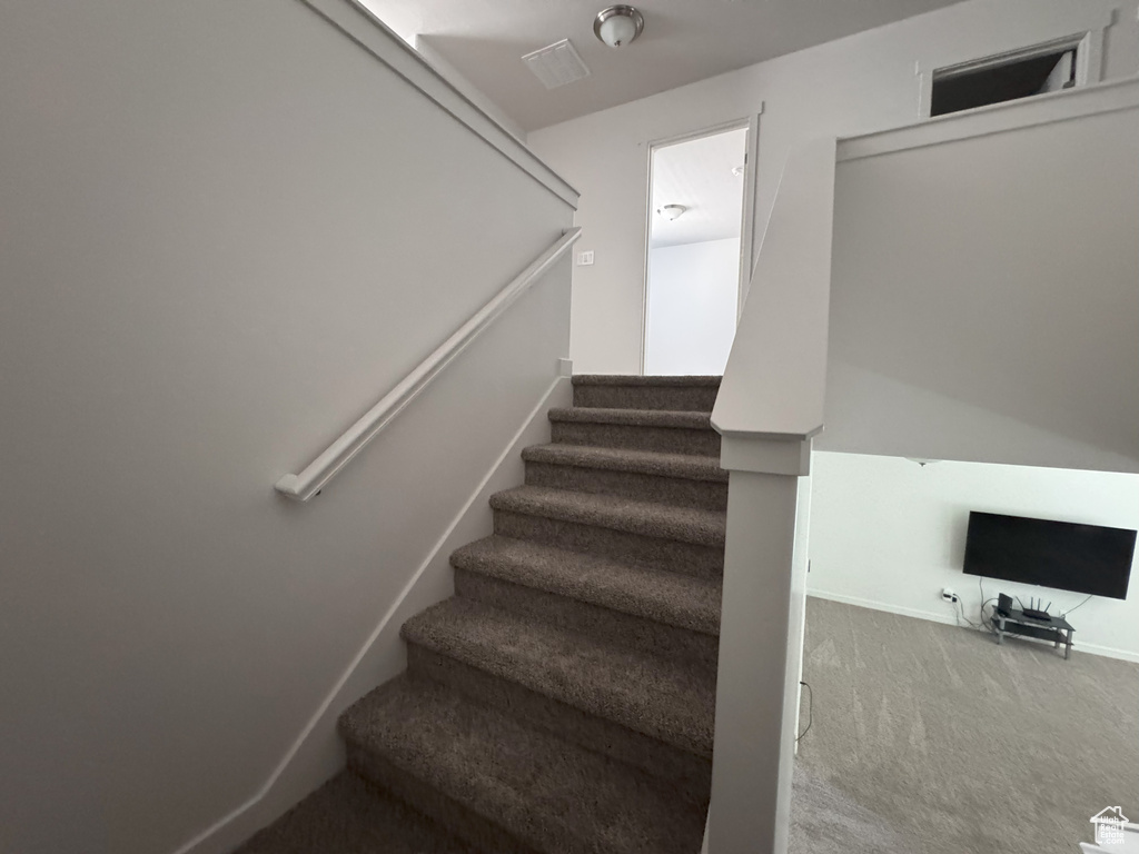 Stairs featuring carpet floors and baseboards
