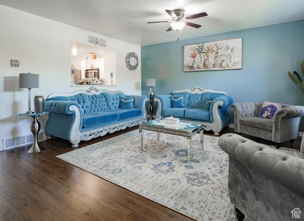 Living area with ceiling fan and wood finished floors