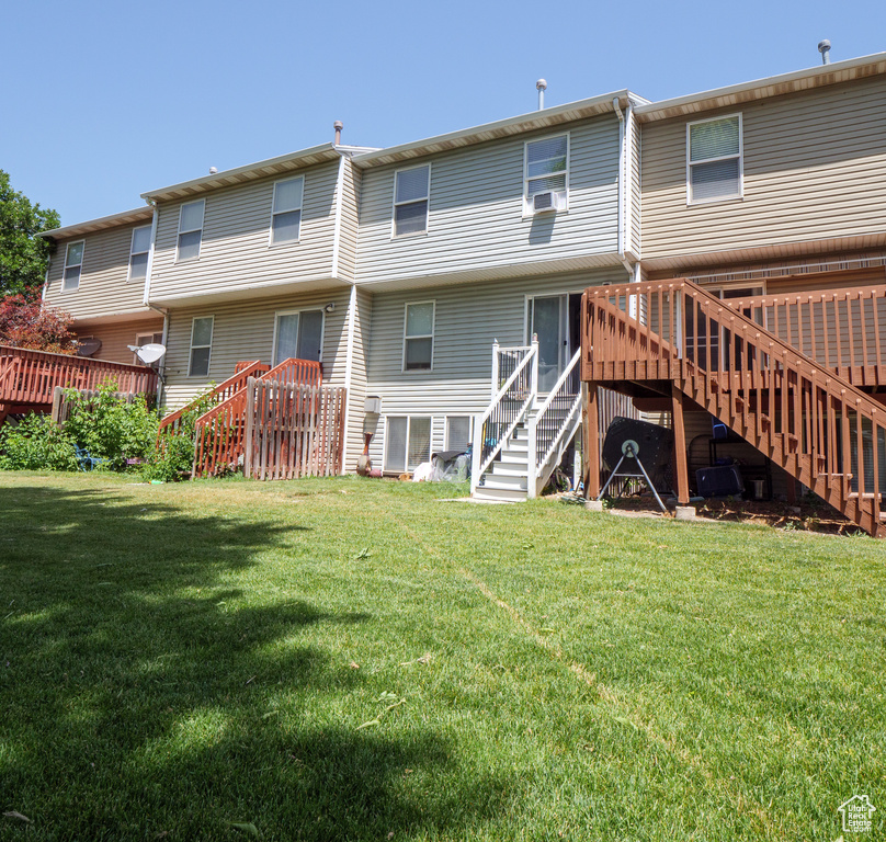 Back of house featuring stairs, a deck, a yard, and cooling unit
