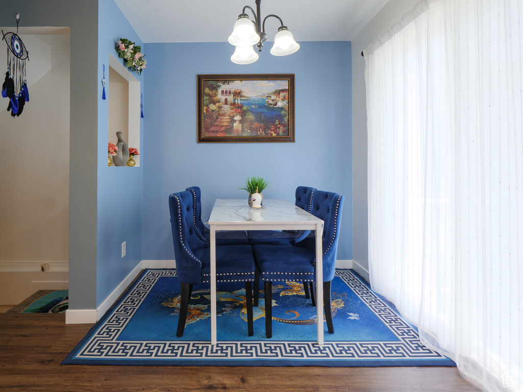 Dining space featuring a chandelier and wood finished floors