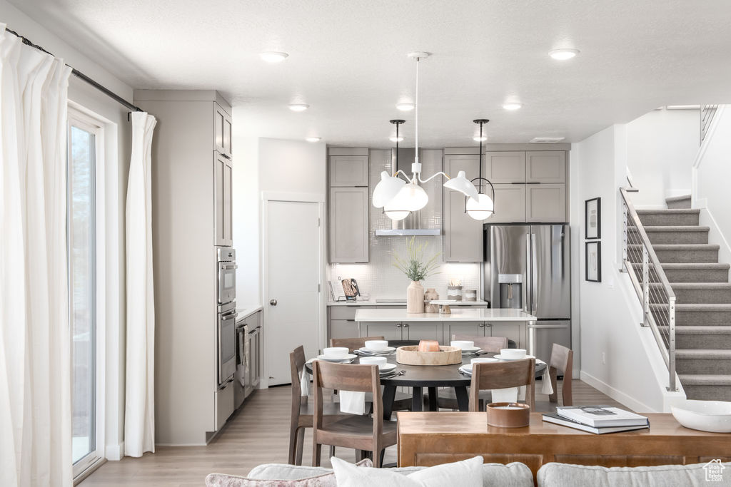 Dining area featuring light wood-style flooring, stairs, and recessed lighting