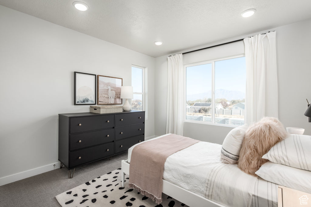 Bedroom with light carpet, multiple windows, and recessed lighting