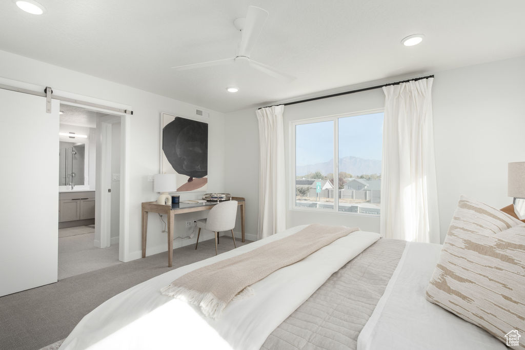 Carpeted bedroom with recessed lighting, an office area, a mountain view, a barn door, and a ceiling fan