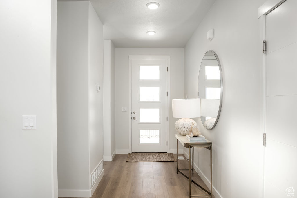 Foyer entrance with wood finished floors and baseboards