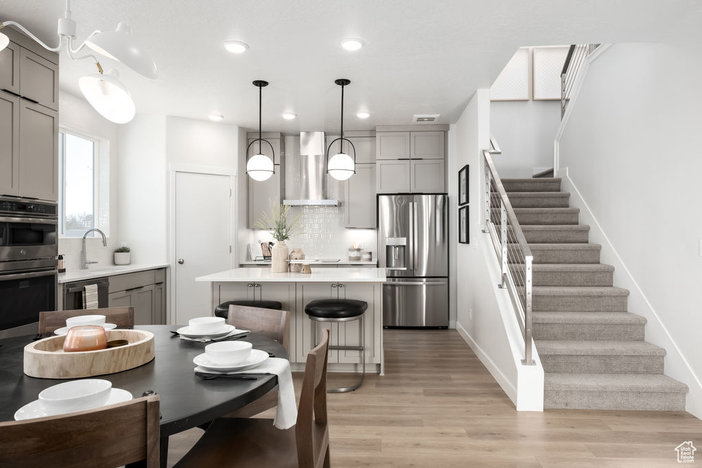Dining area with stairway, light wood-type flooring, and recessed lighting