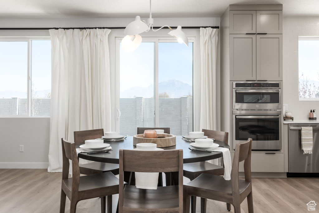 Dining area featuring light wood finished floors and a chandelier