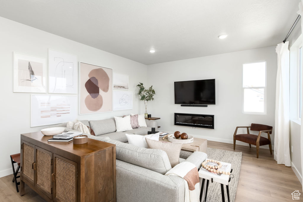 Living area featuring light wood finished floors and recessed lighting