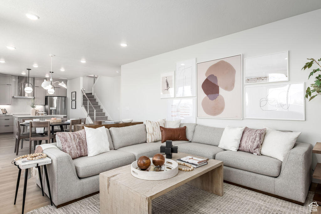 Living room featuring stairway, light wood finished floors, and recessed lighting