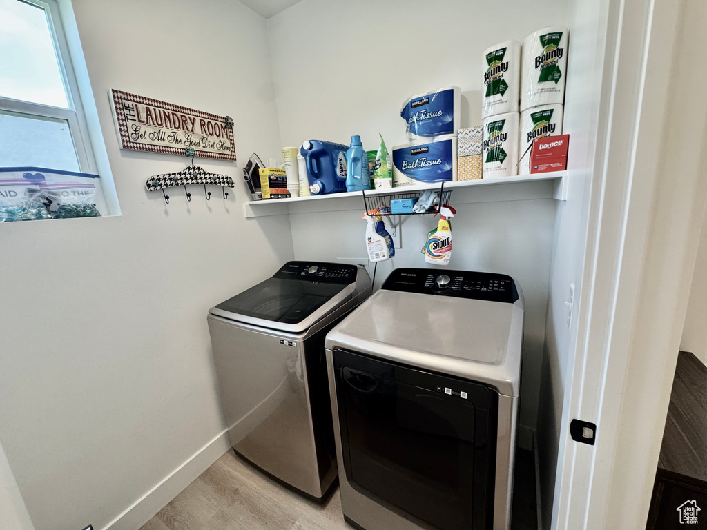 Laundry room featuring independent washer and dryer and light wood finished floors