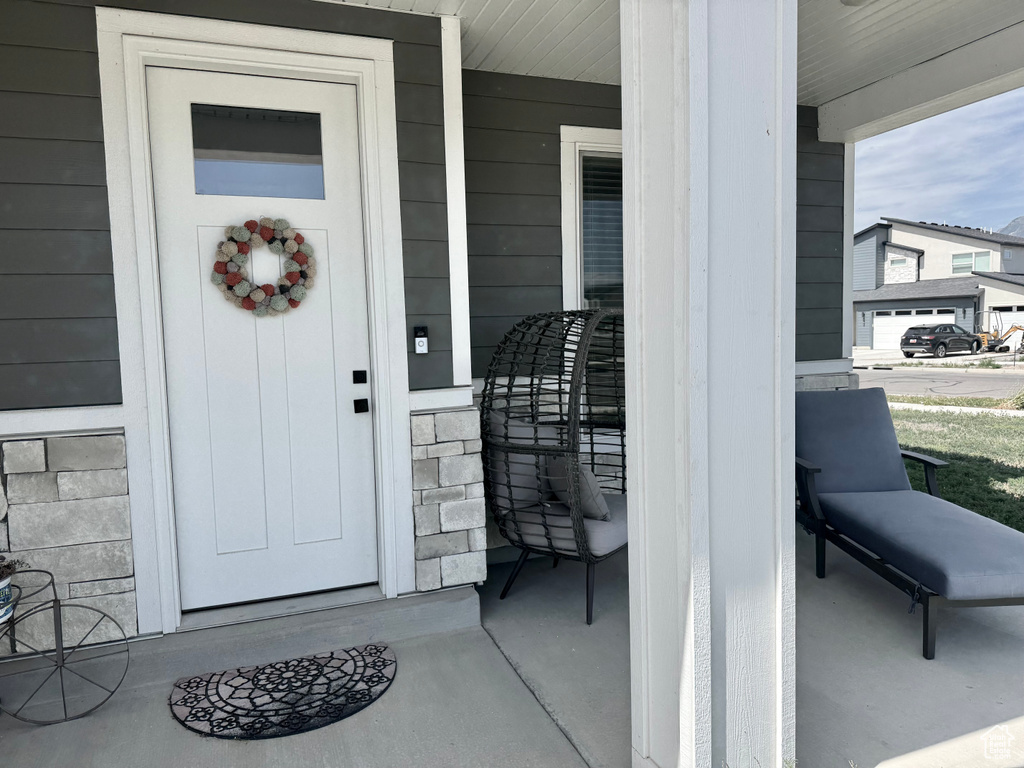 Entrance to property with a porch and stone siding