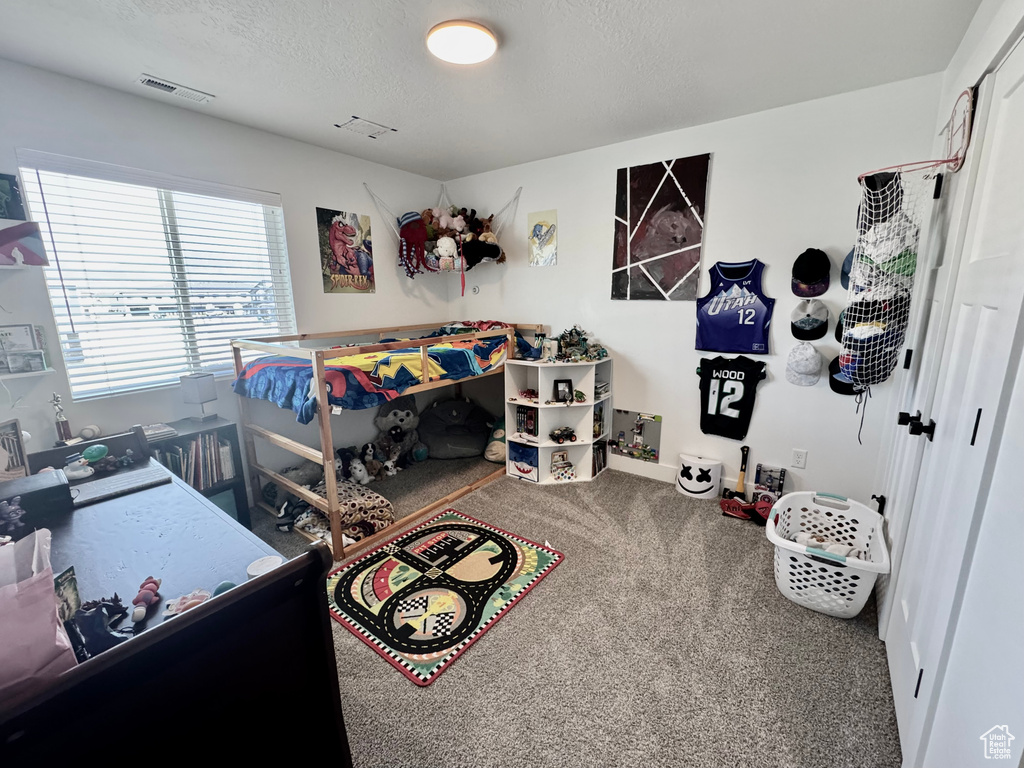 Bedroom featuring carpet flooring and a textured ceiling