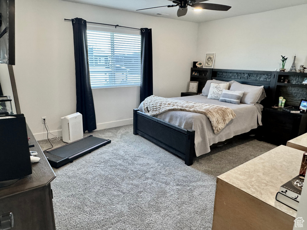 Carpeted bedroom with ceiling fan and baseboards