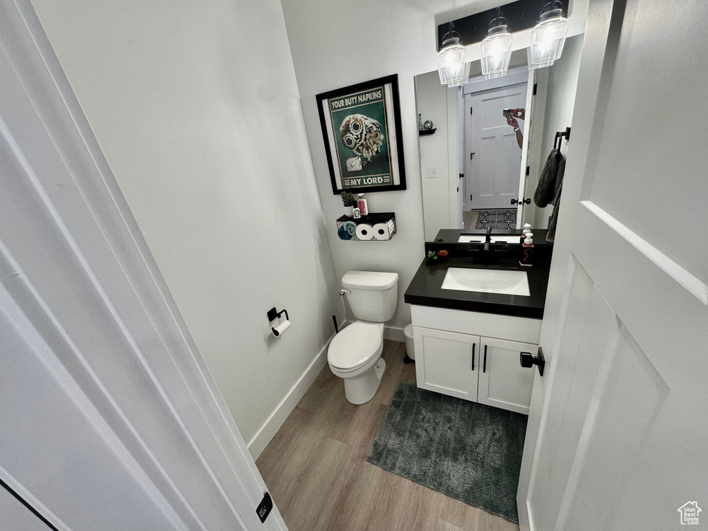 Half bath featuring wood finished floors and vanity
