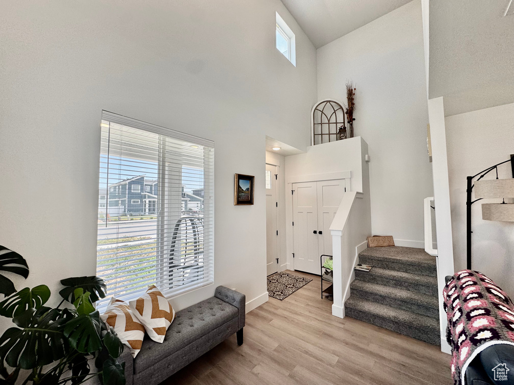Foyer entrance featuring light wood finished floors, stairs, and a high ceiling